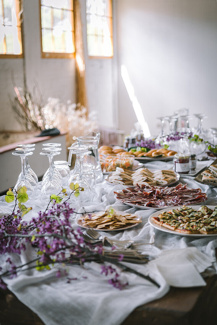 Appetitliche, frisch zubereitete Snacks auf weißen Tellern auf einem Banketttisch mit Tischtuch in einem Restaurant