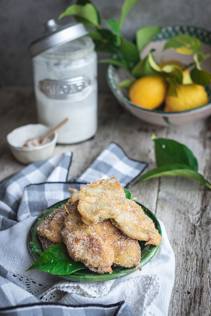 From above plate with paparajotes a typical dessert from Murcia in Spain made with lemon leaves and sprinkled with sugar on rustic wooden table