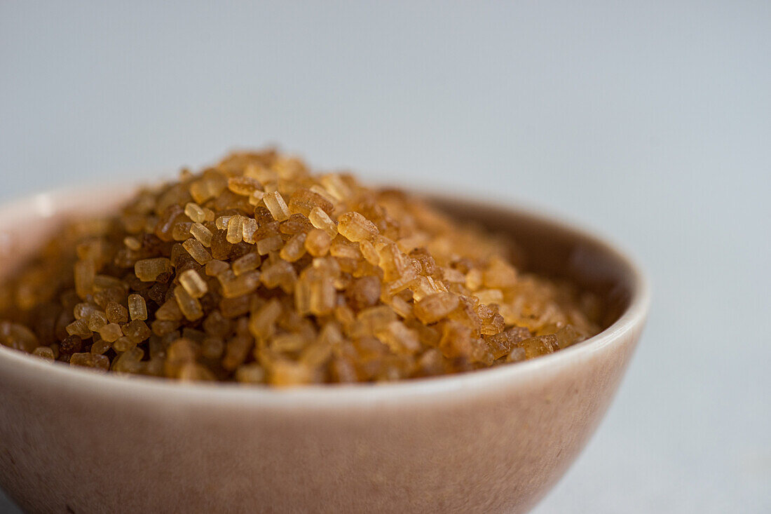 Organic brown textured sugar crystals in the bowl