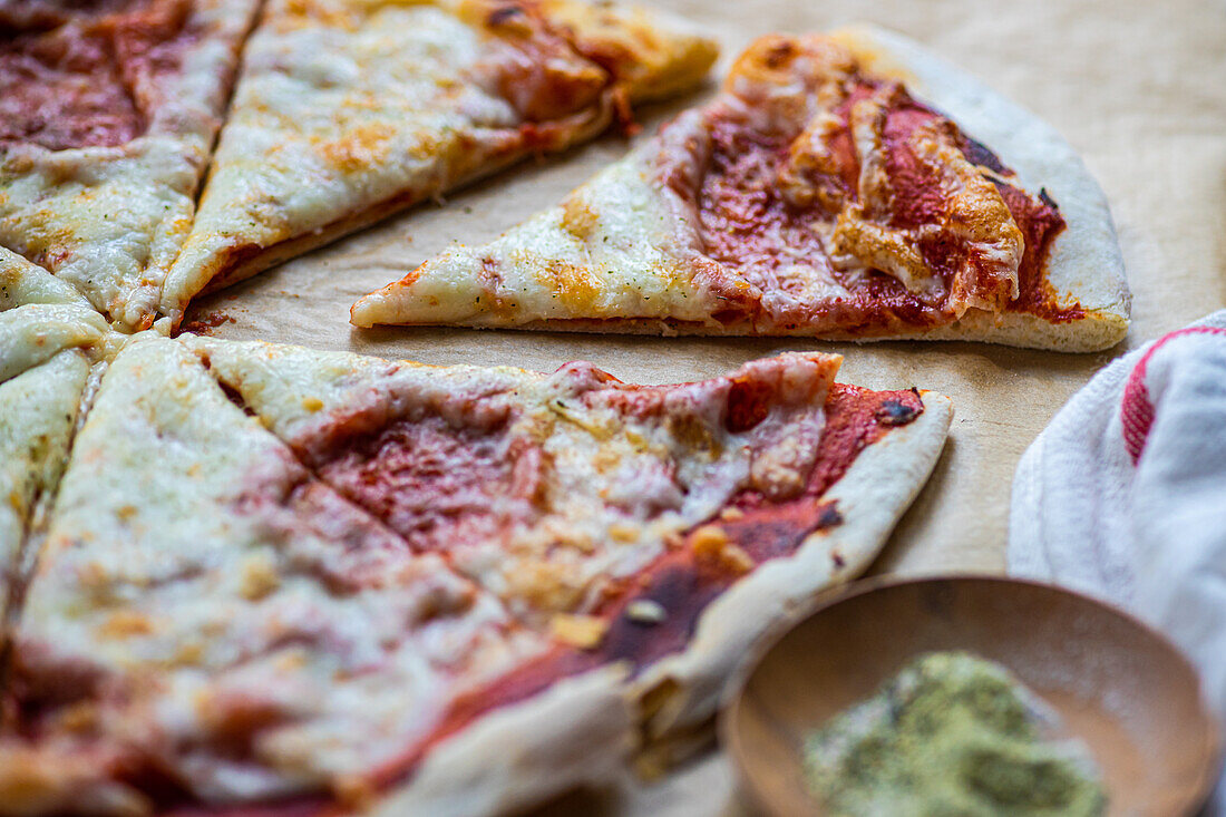 Frisch gebackene hausgemachte Pizza mit italienischen Kräutern und Parmesankäse auf dem Tisch