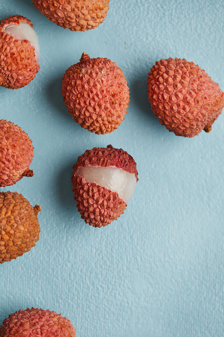 Top view of delicious fresh and opened ripe lychee fruits on smooth surface with grey background