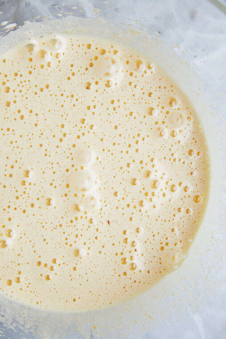 Draufsicht auf Eischnee in einer Schüssel auf einem Marmortisch beim Backen von Gebäck