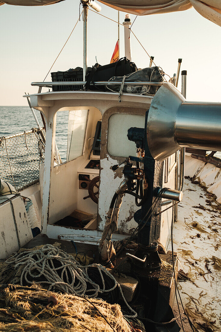 Captain cabin on dirty deck with leftovers of fish and fishing equipment on trawler floating in open sea in Soller near Balearic Islands of Mallorca