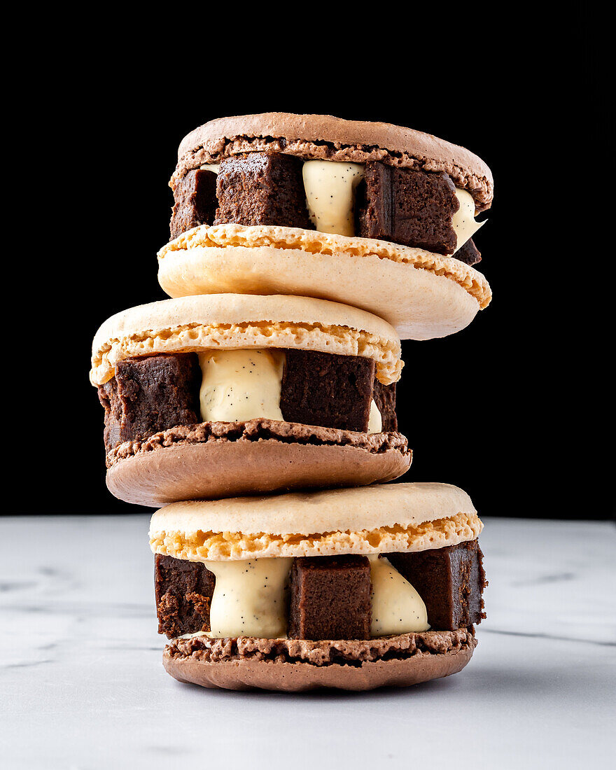 Chocolate brownie tasty macaroons against marble table and black background