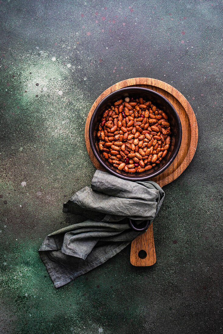 From above uncooked red kidney beans in the pan on concrete table