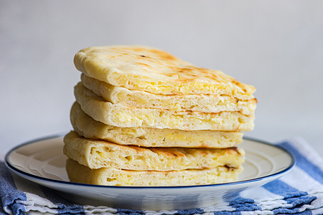 Fokus Traditionelles georgisches Gericht "Imeruli khachapuri" (Brotkuchen) mit Sulguni-Käse auf dem Teller