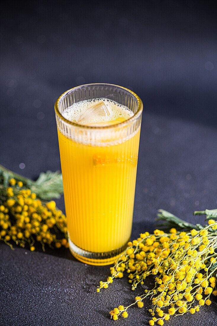 Close up of Mimosa cocktail in the glass on black stone table