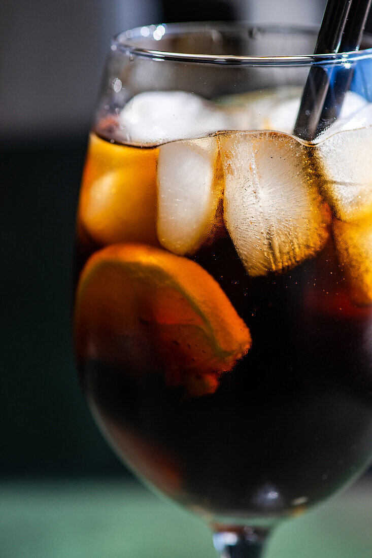 Alcohol cocktail Cuba Libre with orange slice and ice in the glass