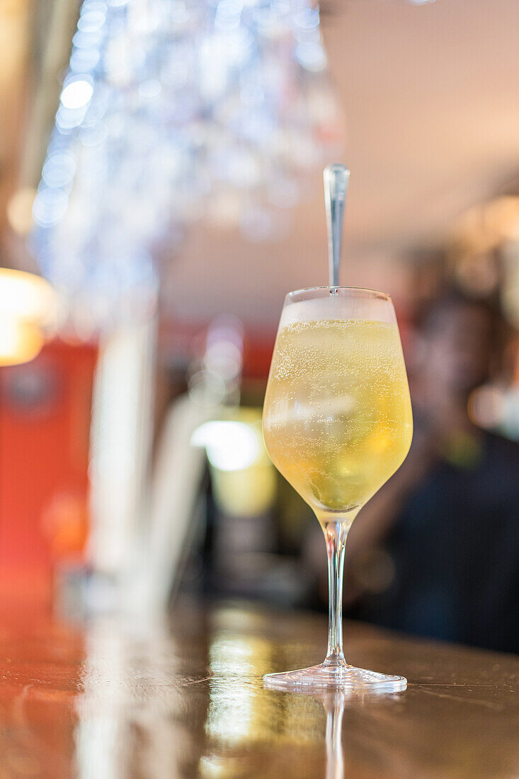 Glass of cold fresh cocktail served on glass on wooden counter in bar