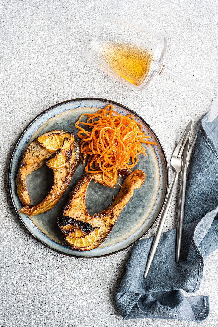 Lachssteak mit pikanter Karotte, serviert mit einem Glas trockenem Weißwein