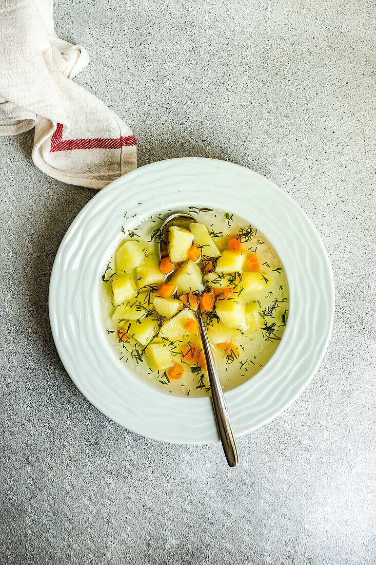 Bowl with healthy vegetable soup with carrot and potato