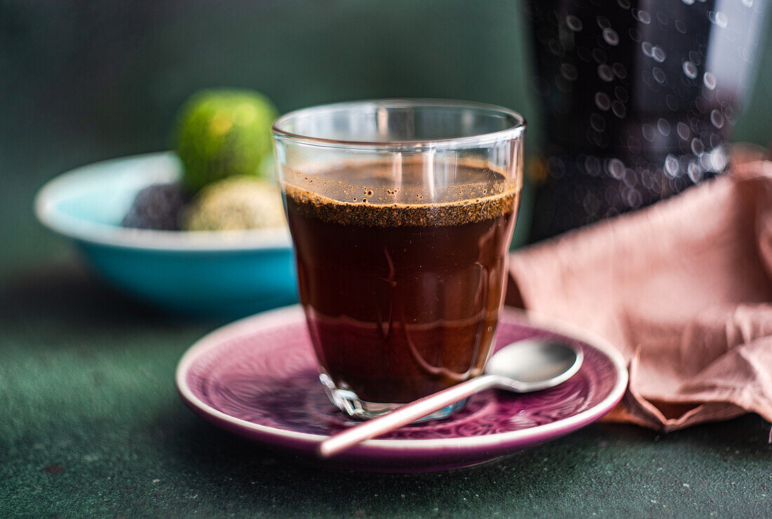 Geyser coffee maker near glass of coffee and traditional turkish pakhlava on concrete table