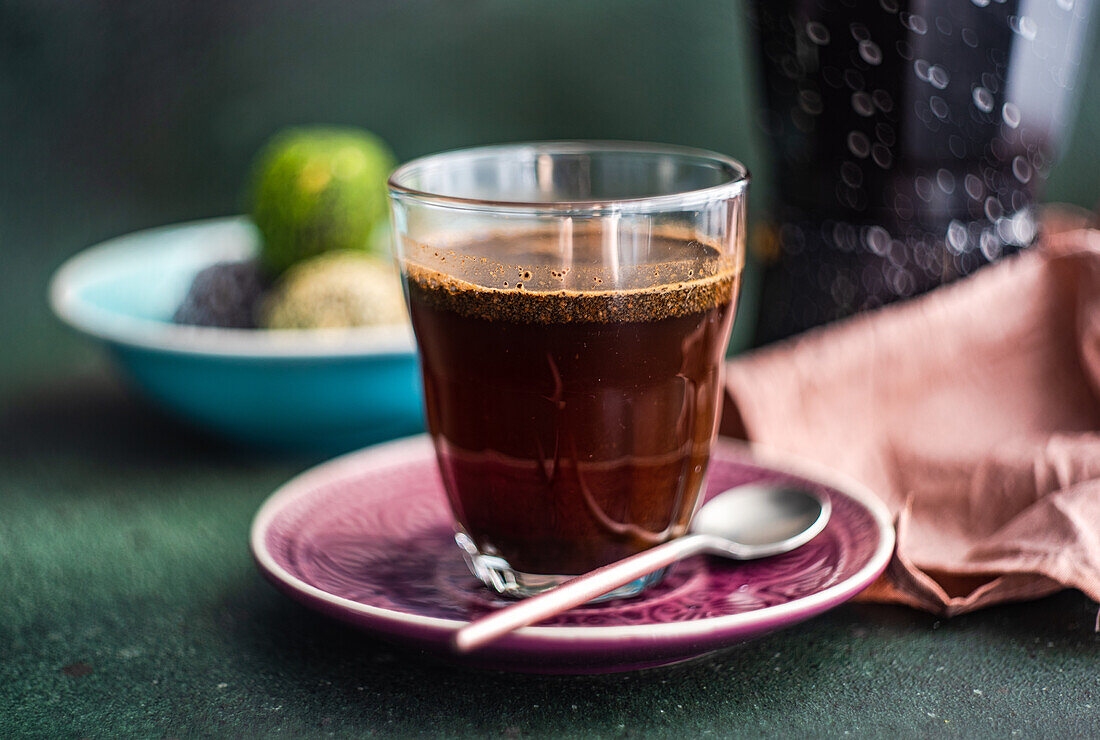 Geysir-Kaffeemaschine neben einem Glas Kaffee und traditioneller türkischer Pakhlava auf einem Betontisch