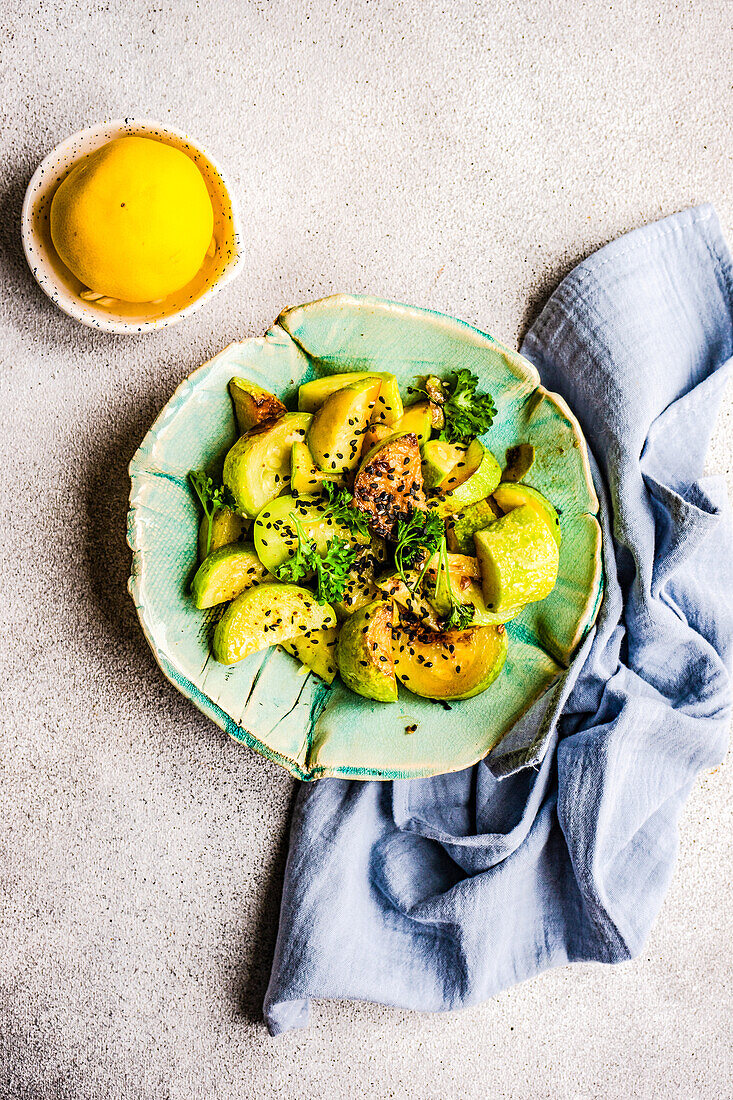 From above sliced of grilled zucchini vegetable in the bowl with sesame seed