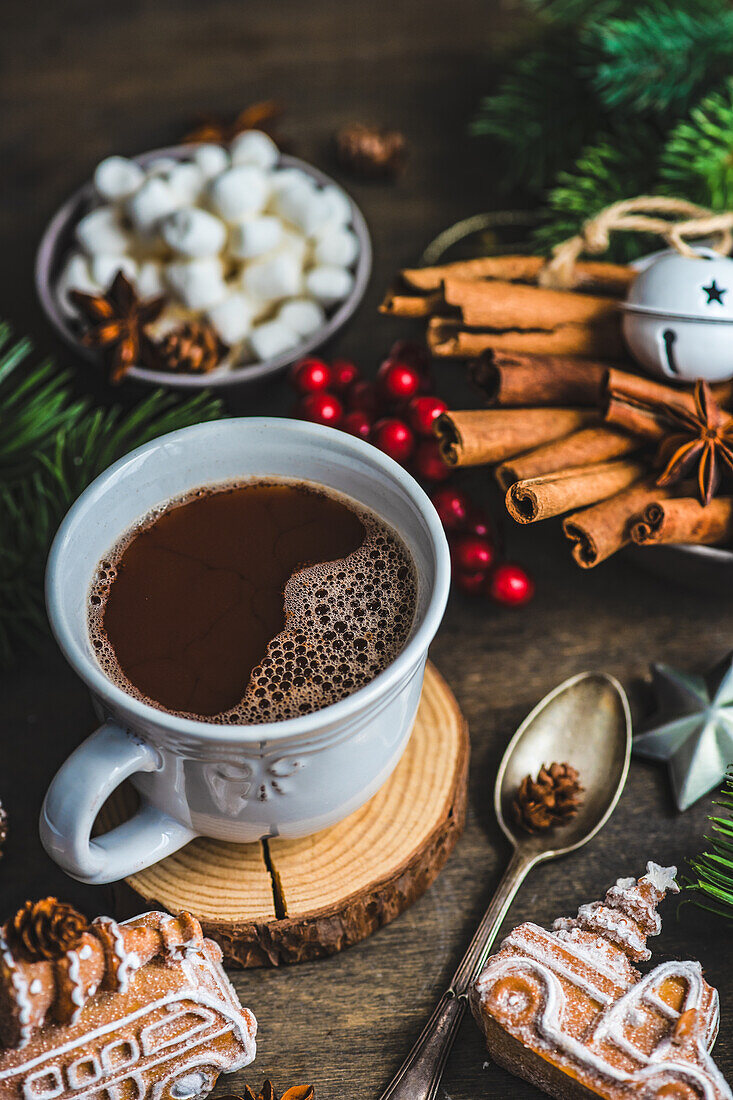 Von oben Becher mit heißer Schokolade und Mini-Marshmallows mit Gewürzen auf Hintergrund mit Weihnachtsdekorationen