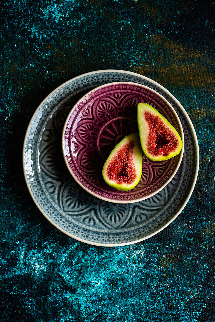 Ripe fig slices on the plates on concrete background