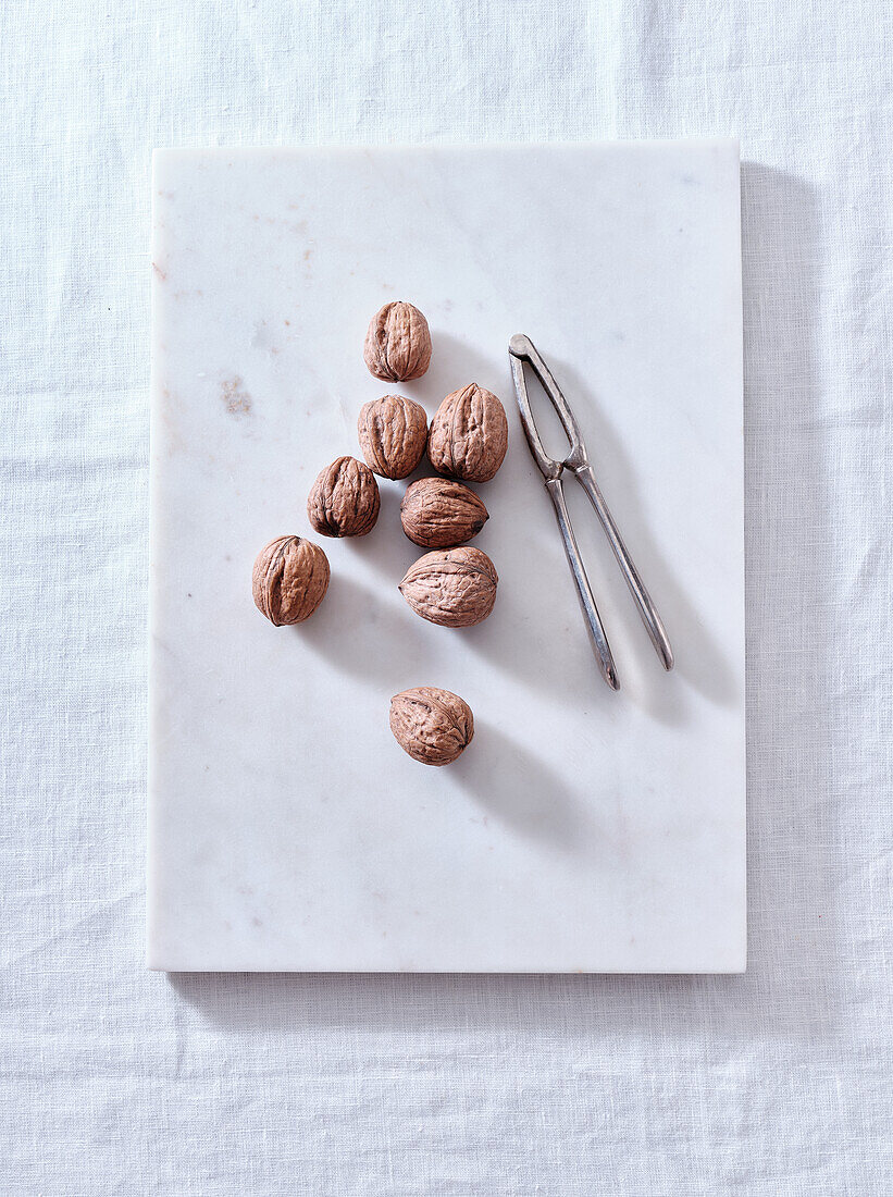 Opening walnuts with a cracker top view. White background