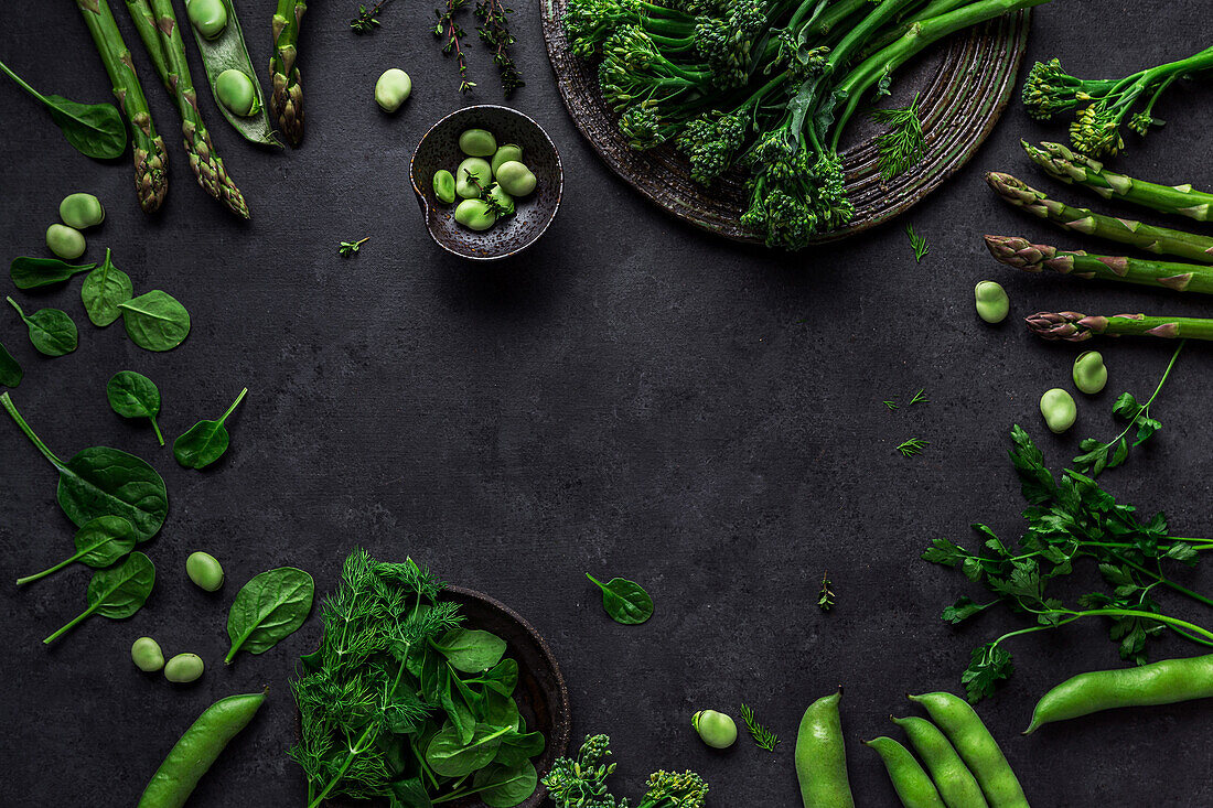 Overhead-Komposition von organischen vegetarischen gesunden Grünzeug von Trauben und Schoten, Blätter und Bohnen auf dem Tisch