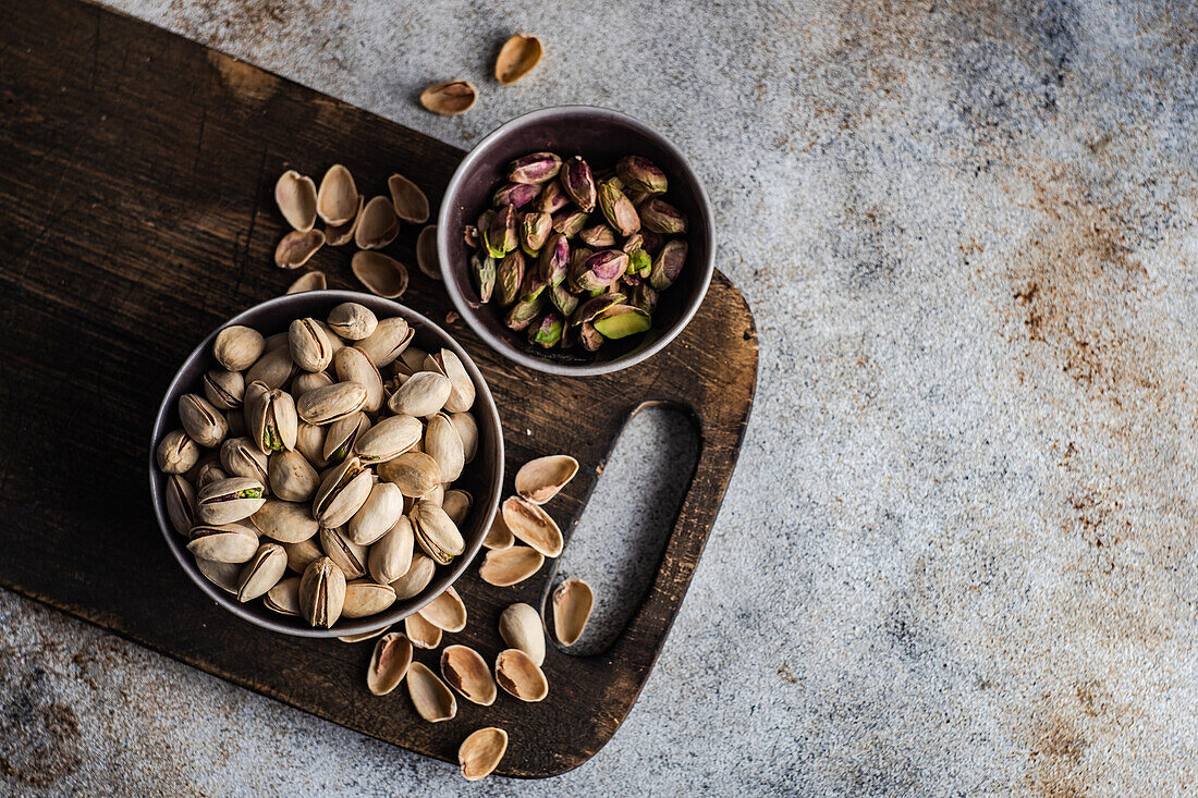 From above bowls with different kinds of nuts on concrete table background