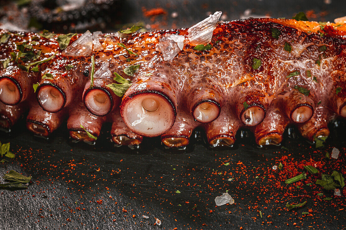 Köstliche gegrillte Oktopus-Tentakel, serviert mit Gewürzen auf einem Holzbrett
