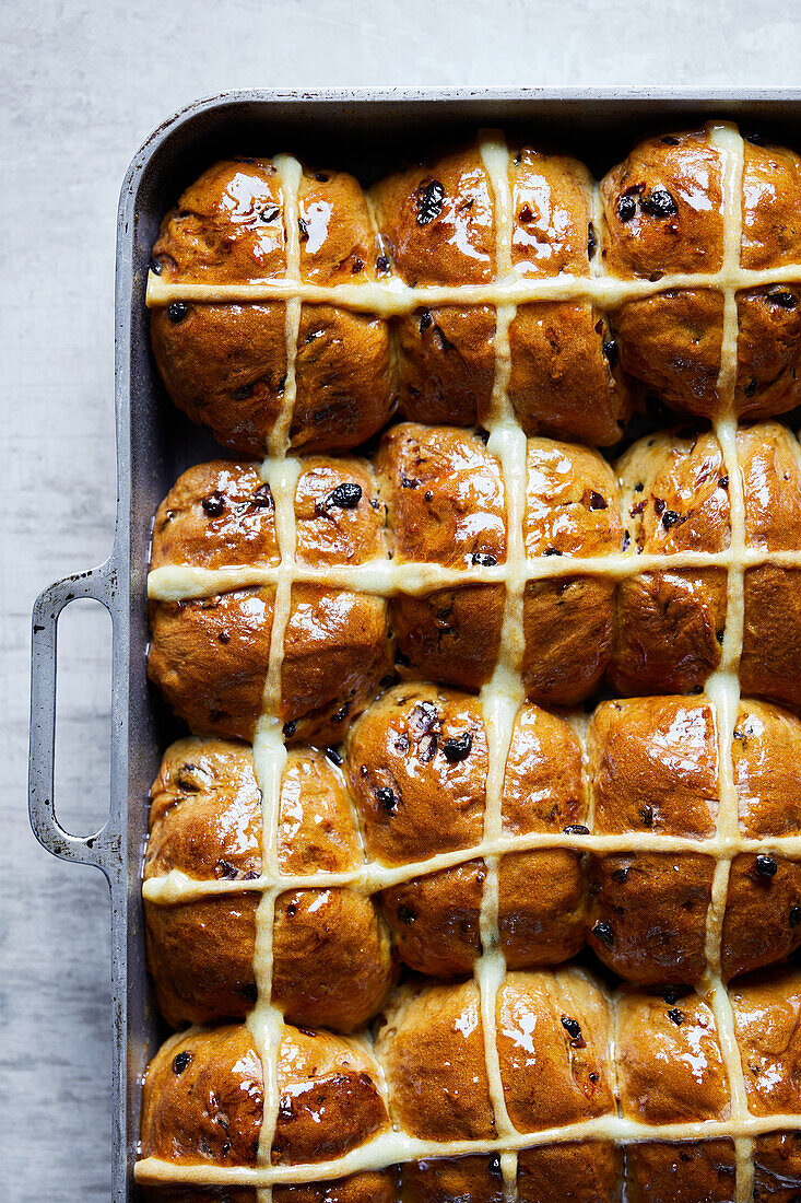 Top view full frame background of delicious baked homemade hot cross buns with cream and raisin