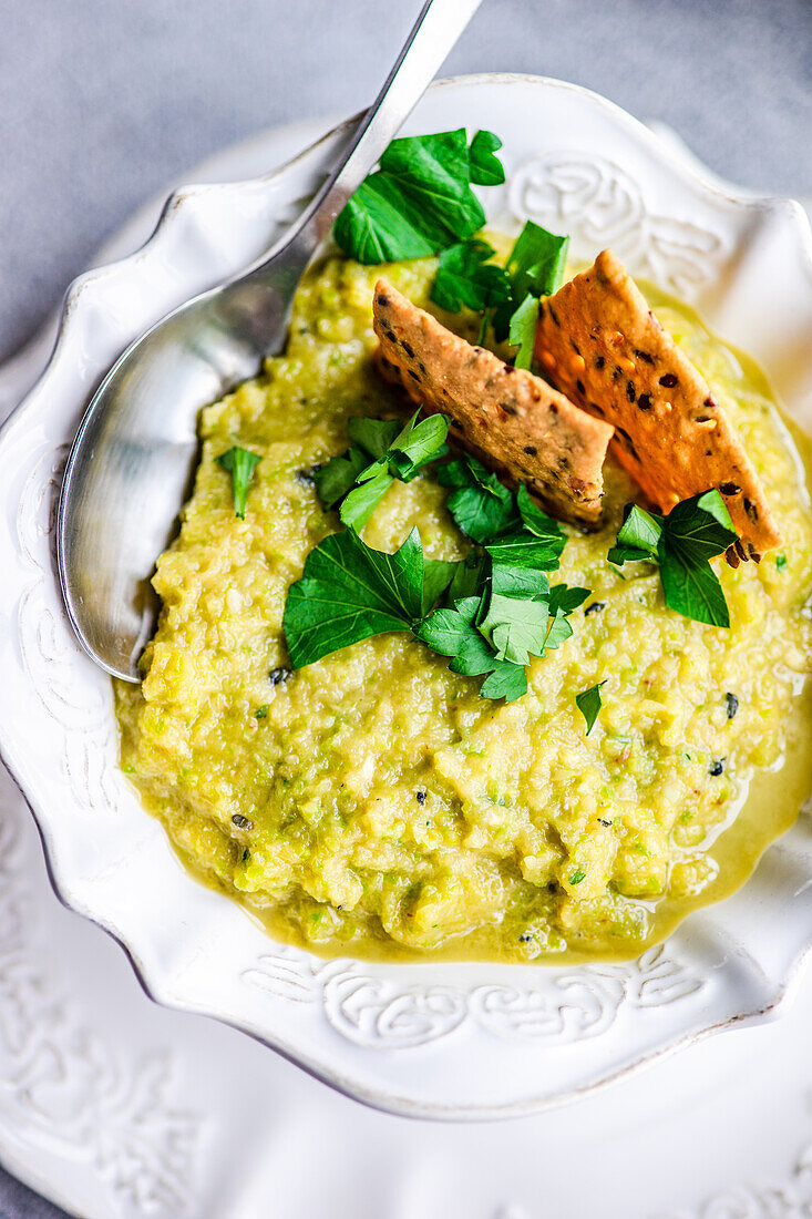 From above healthy zucchini soup in the bowl with crackers