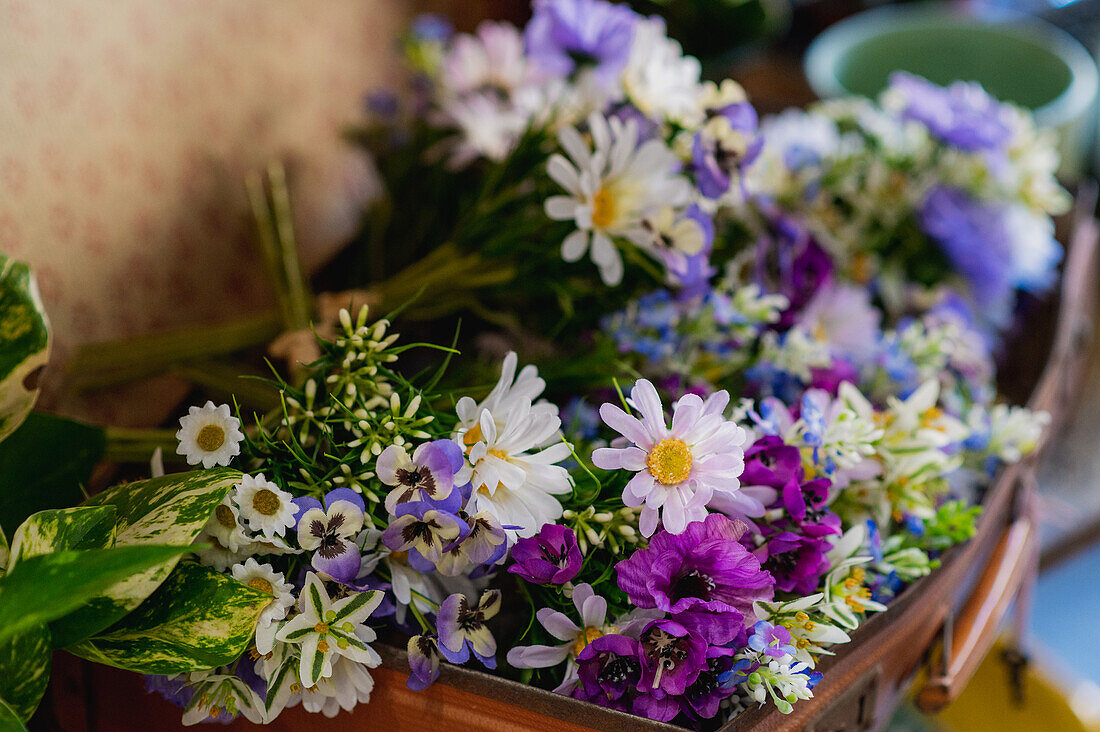 Zarter bunter Blumenstrauß aus verschiedenen frischen Wildblumen in einem Korb in einem Blumenladen