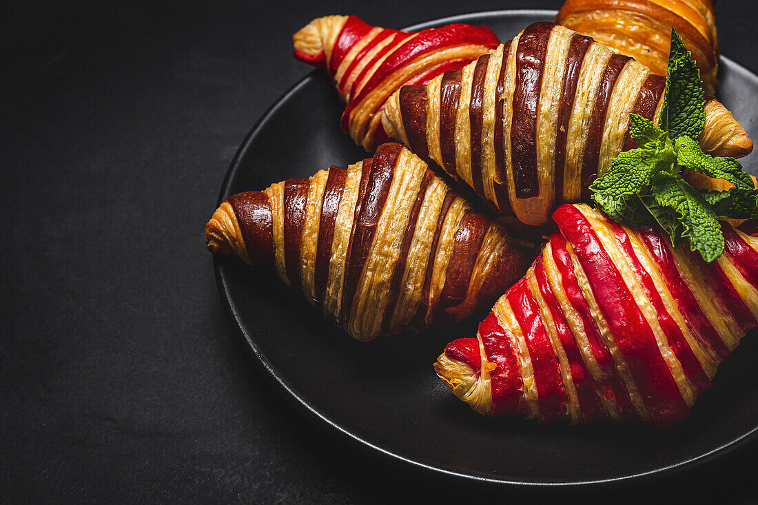 Blick von oben auf verschiedene süße Croissants, die in einem Korb auf dem Frühstückstisch serviert werden