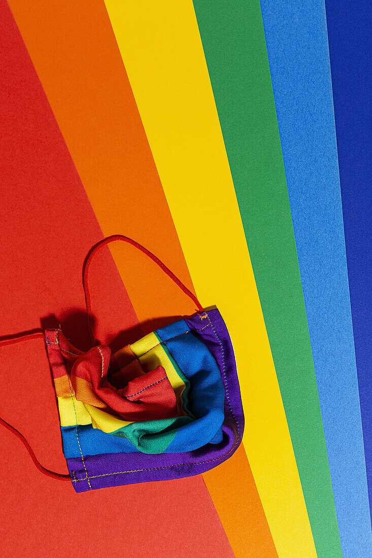 From above of bright textile mask with striped rainbow ornament during COVID 19 pandemic