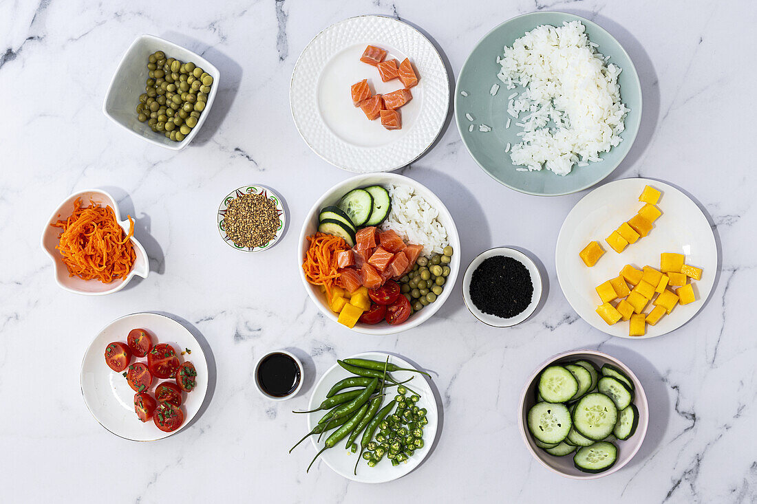 Top view of assorted fresh ingredients for traditional oriental poke preparation placed on marble tabletop