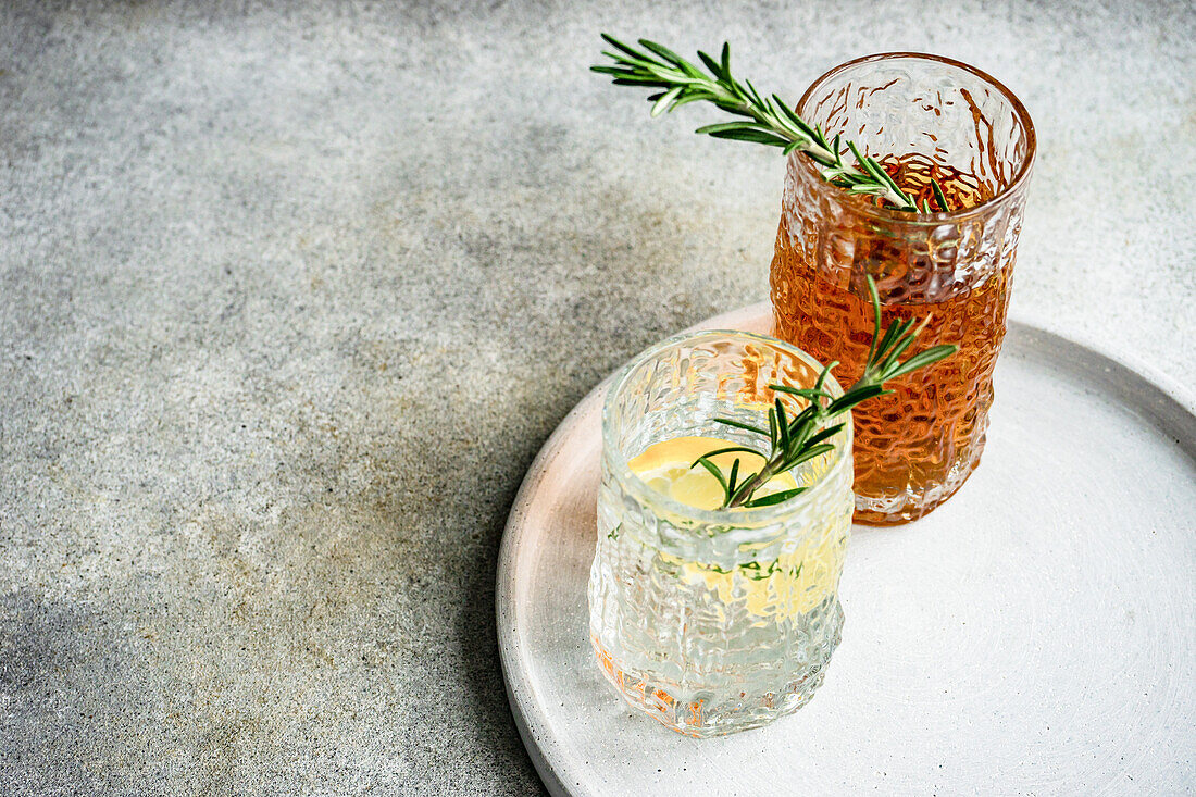 From above alcoholic cocktails in the crystal glass with fresh rosemary and lemon slice