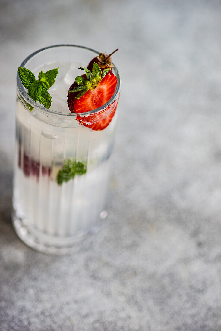 Sommercocktail mit Eis und Beeren, serviert in einem Kristallglas