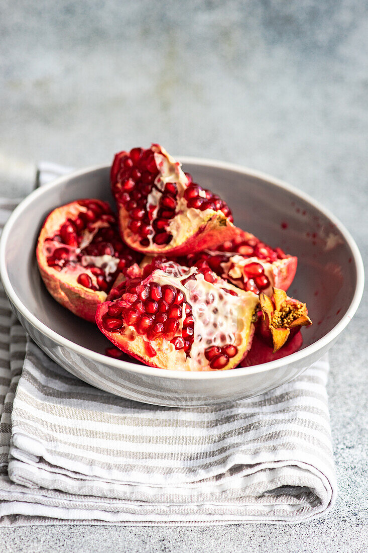 Ripe organic pomegranate fruit on the ceramic plate and tea towel