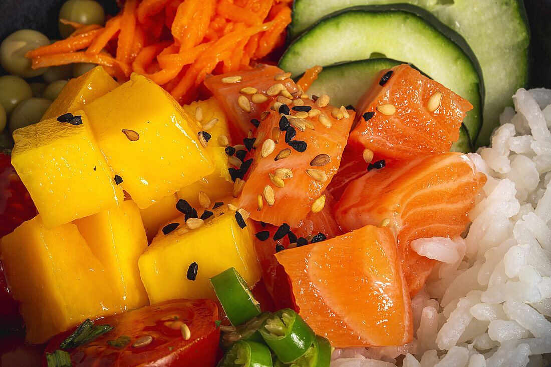 High angle of Asian poke with salmon and rice with assorted vegetables served in bowl on table in restaurant