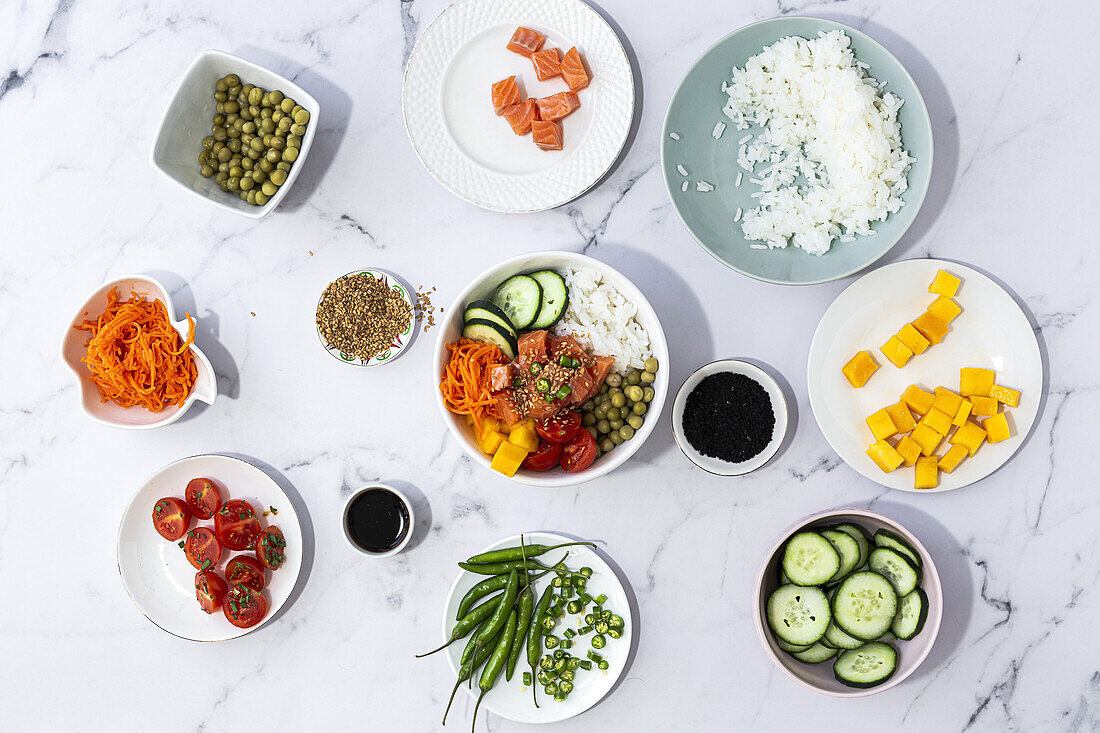 Top view of assorted fresh ingredients for traditional oriental poke preparation placed on marble tabletop