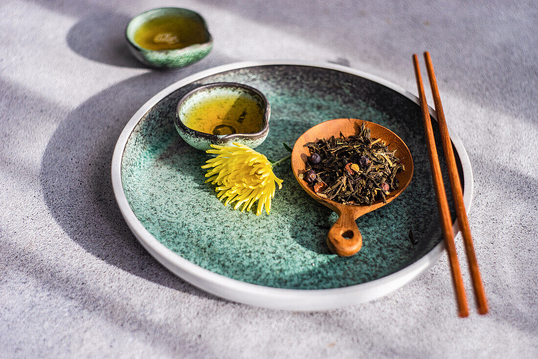 Asiatisches Grünteeset mit gelben herbstlichen Chrysanth-Blüten auf Betontisch serviert