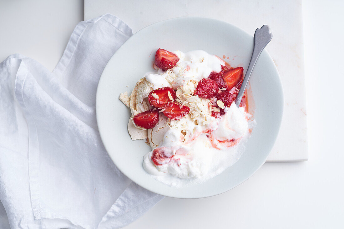 Top view image of a dessert with berries, meringue and whipped cream. Eton's mess with strawberries, sweet treat with summer mood