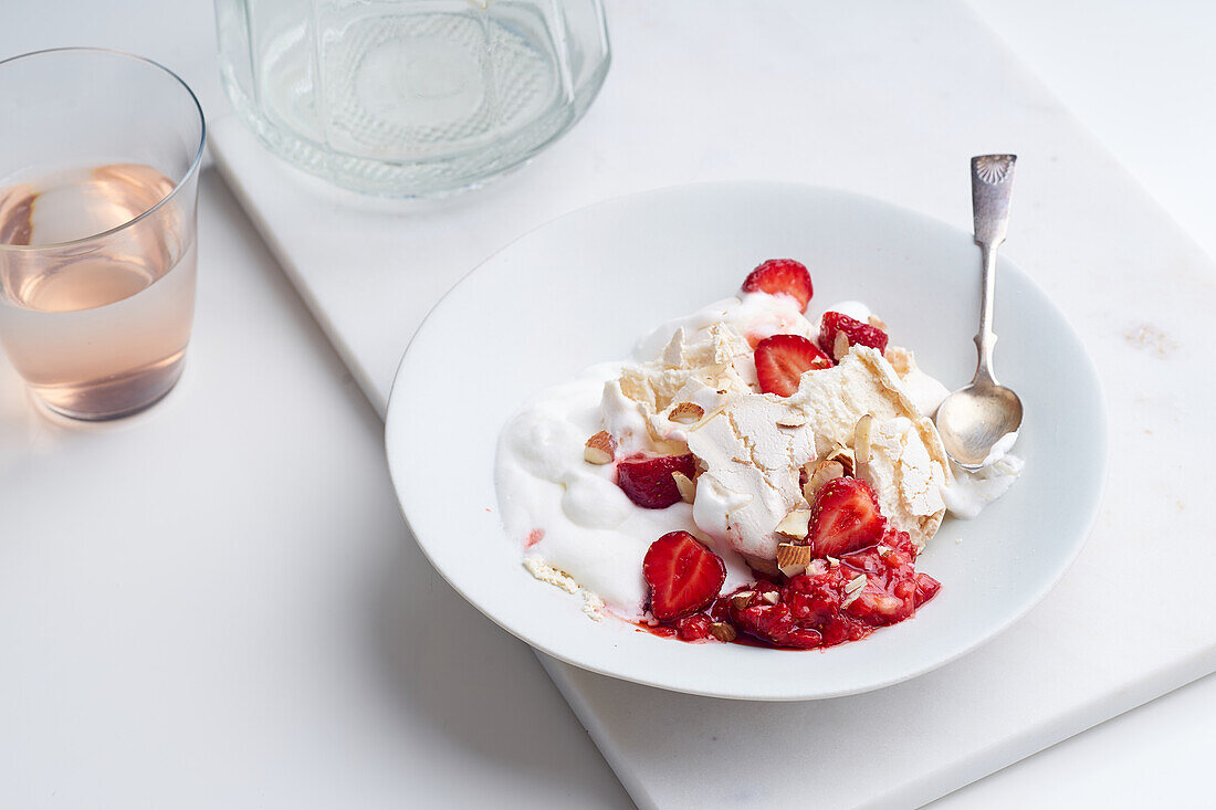 Dessert mit Beeren, Baiser und Schlagsahne. Eton's Mess mit Erdbeeren, süße Leckerei mit Sommerstimmung