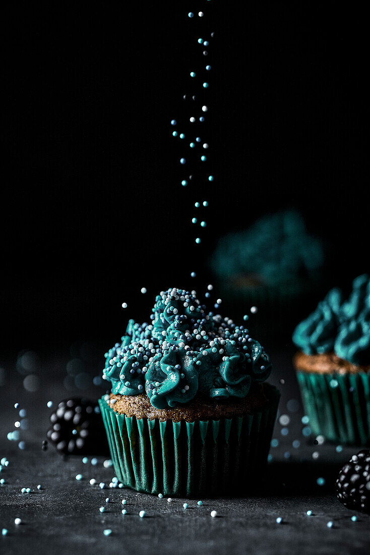 Frischer schöner festlich gebackener Muffin mit leckerem blauen Pudding und Streuseln bei der Dekoration