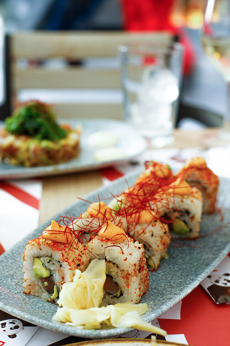 Hoher Winkel von appetitlichem Murakami-Sushi mit Stäbchen und einem Glas Bier auf einem Tisch in einem Restaurant