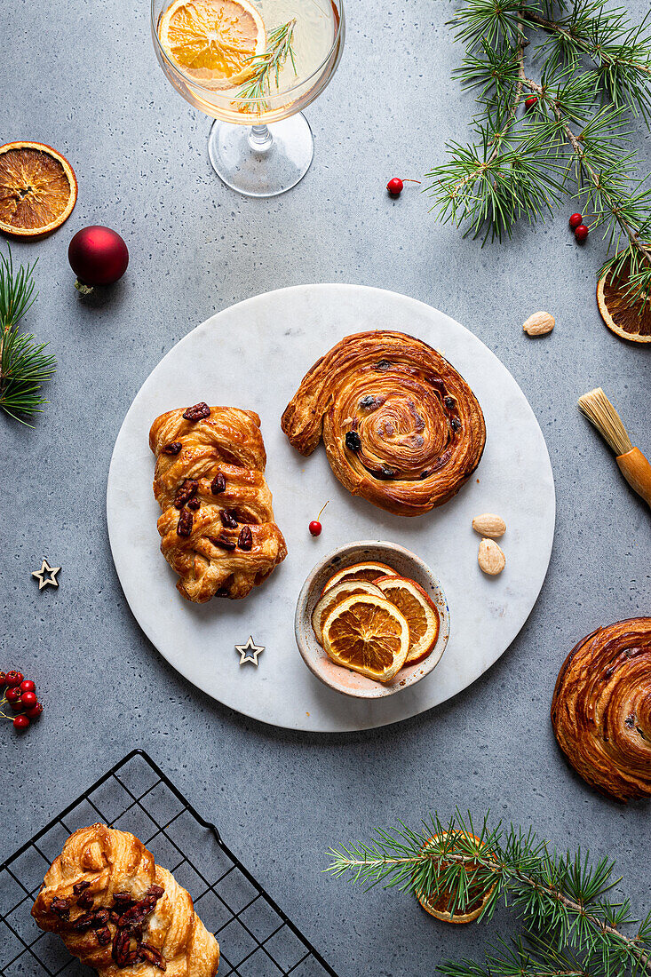 Top view of delicious homemade baked assorted pastries placed on plate with Christmas decoration around