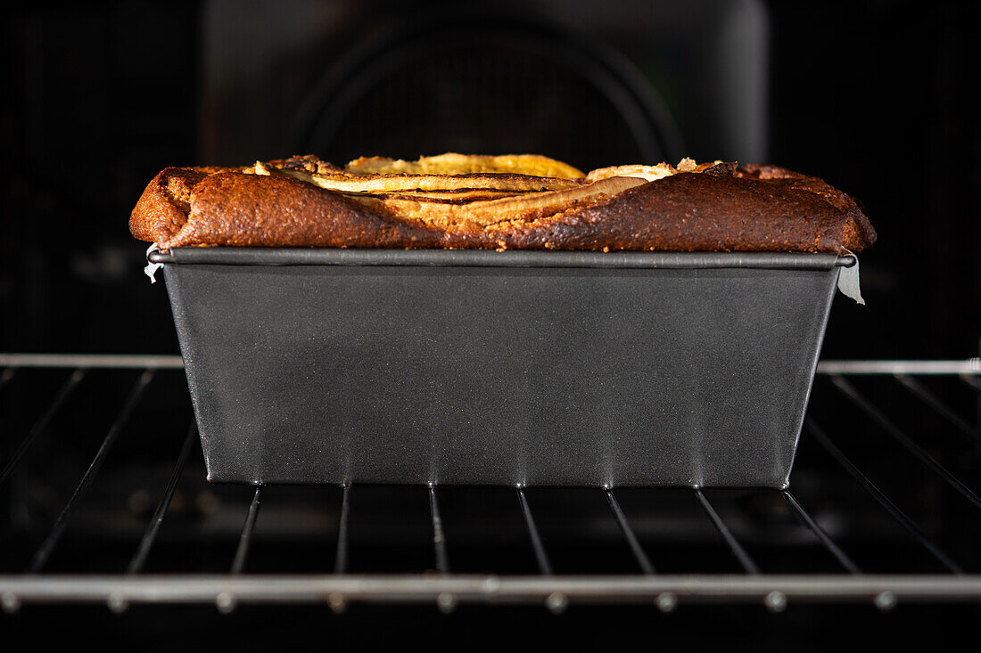 Side view healthy banana bread in container in oven