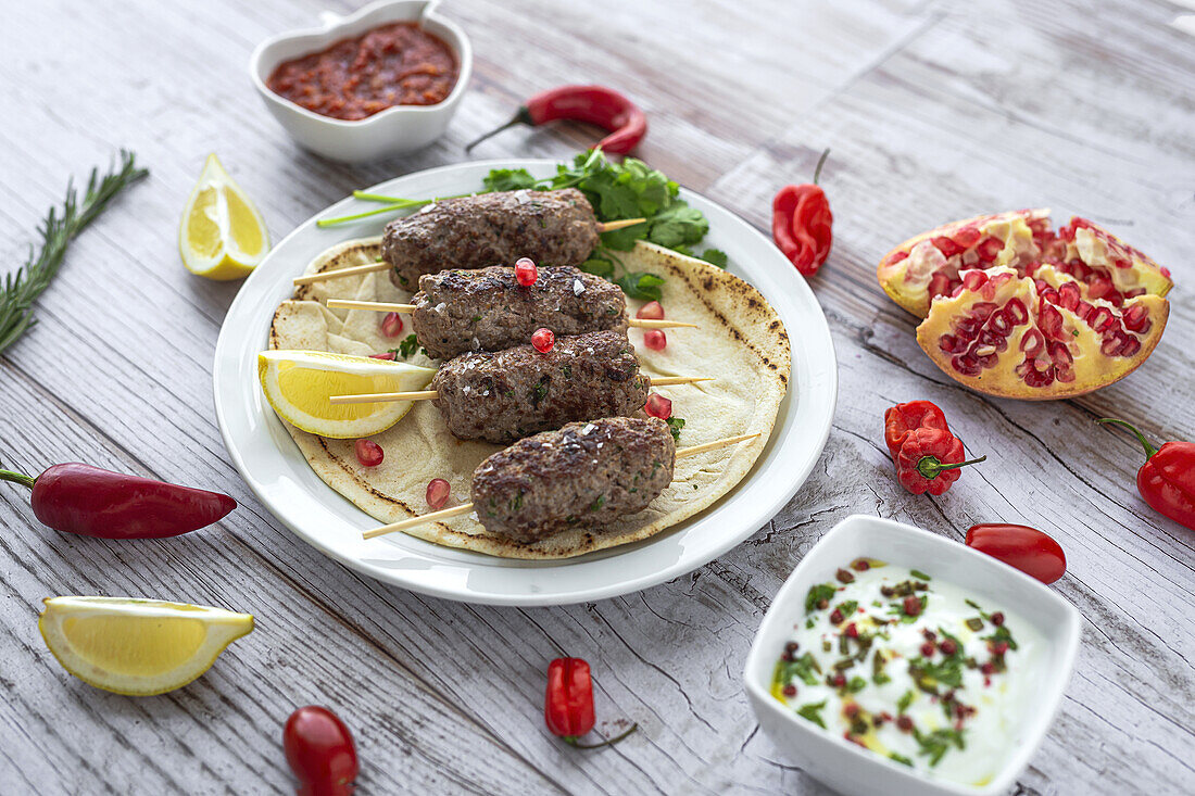 Traditional homemade kafta or kofta kebab beef and lamb with tomato sauce and yoghurt. Traditional Arabic and Turkish food. Halal food