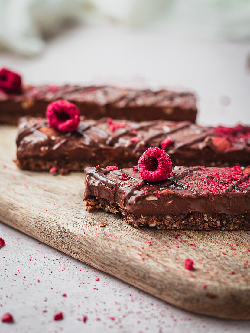 Close up of several chocolate bars with raspberry on a table