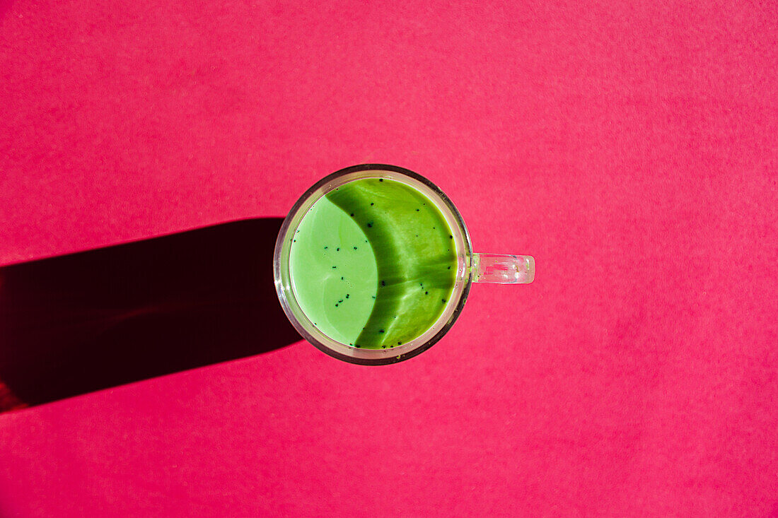 Top view of traditional oriental matcha drink for health and energy on bright pink background