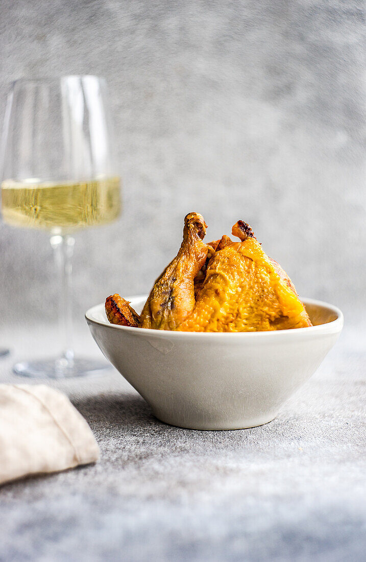 Georgian chicken tabaka dish served for the dinner with white dry wine in glass