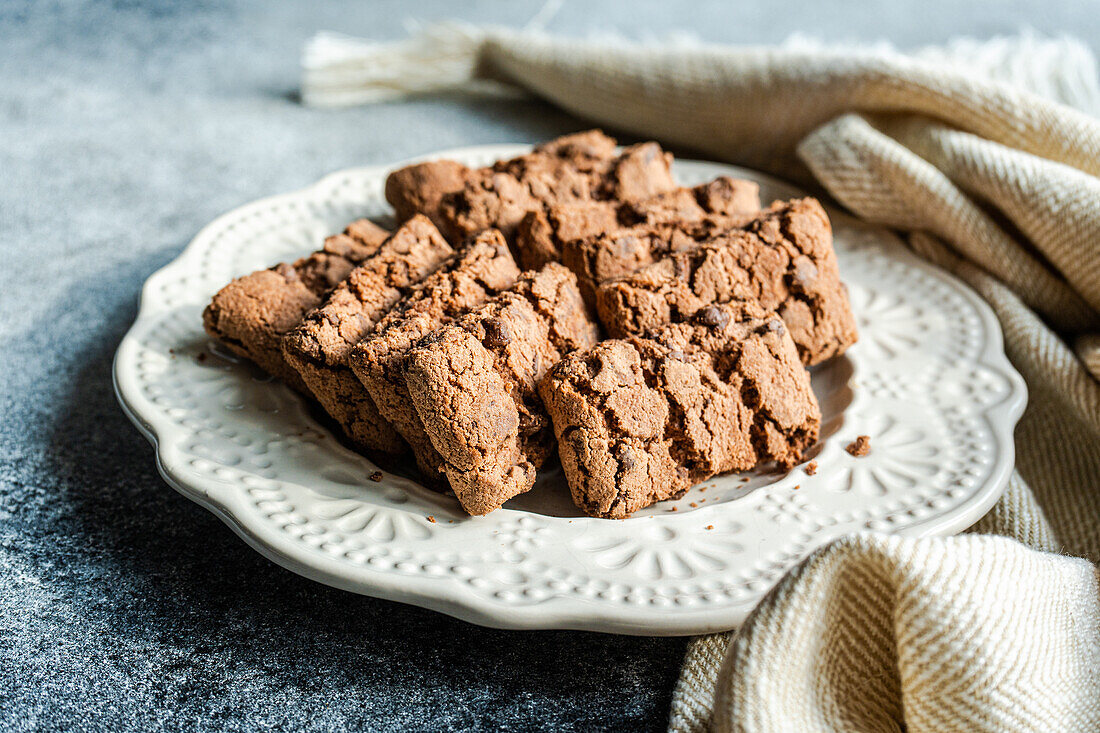 From above ceramic plate with fresh baked chocolate cookies on concrete background