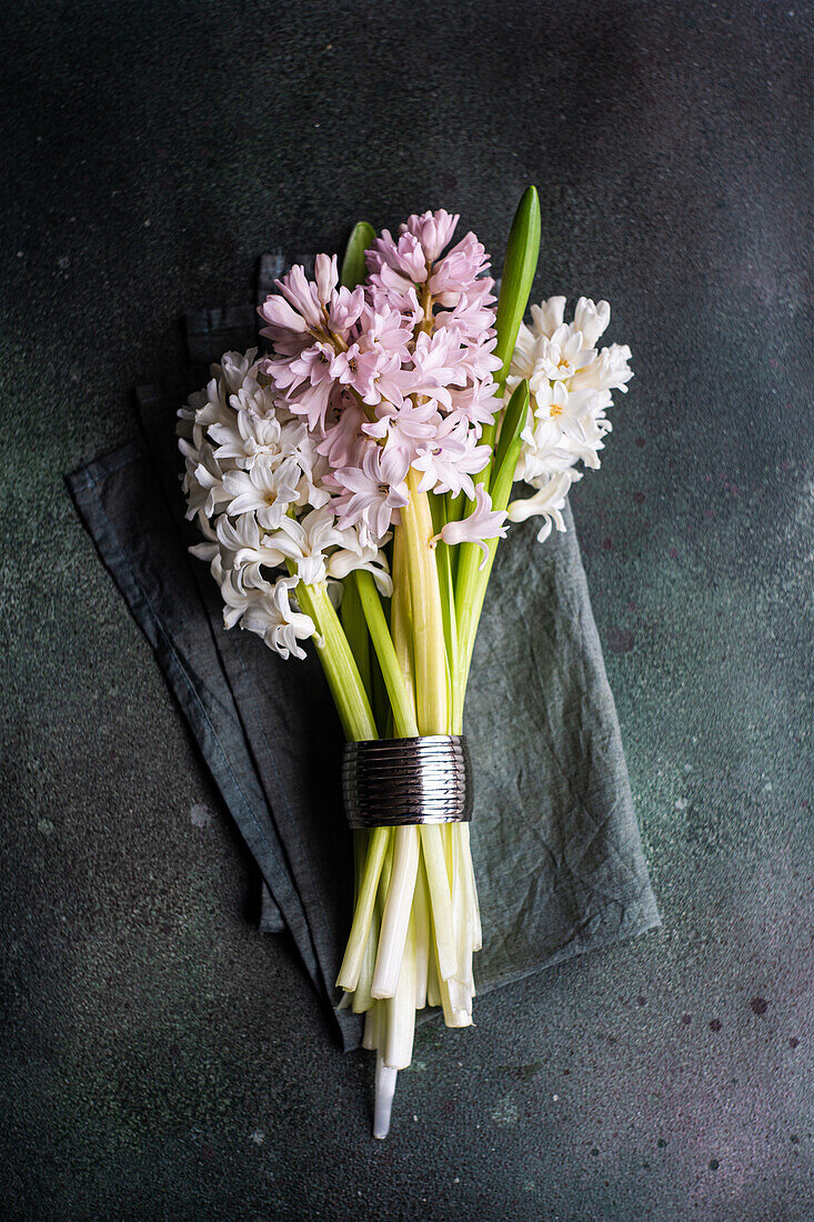 From above spring table setting with hyacinth flowers on dark concrete table for festive dinner