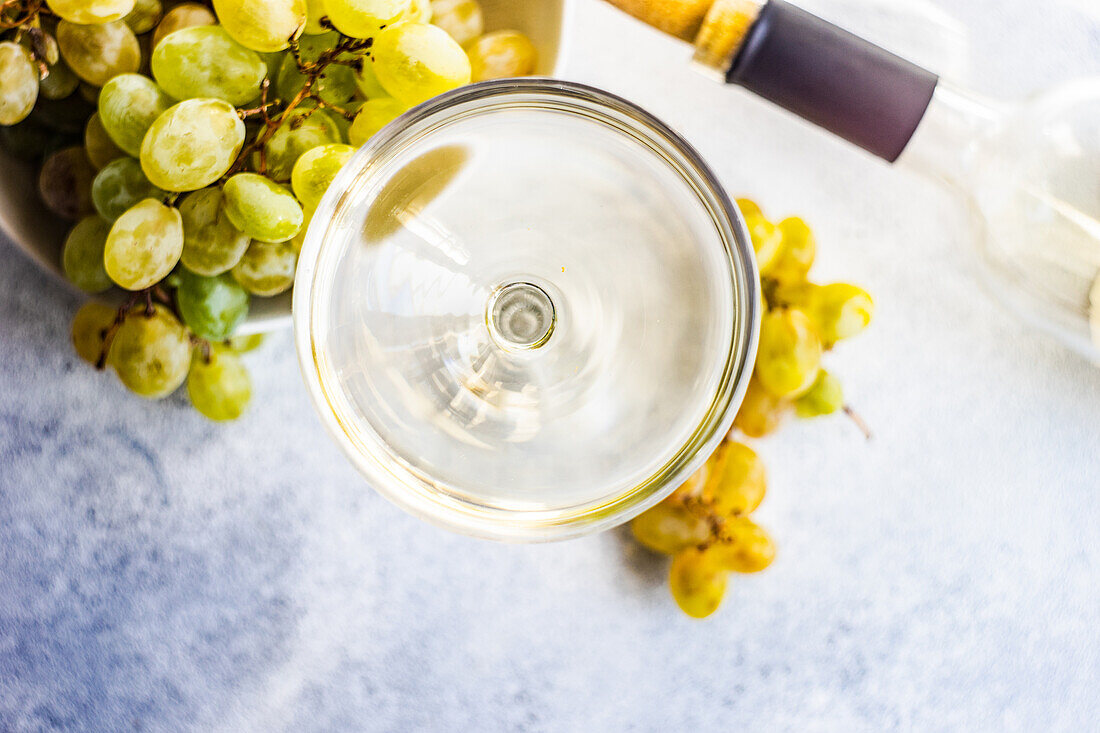 Georgian Mtsvane wine in glass and fresh raw grape on rustic table