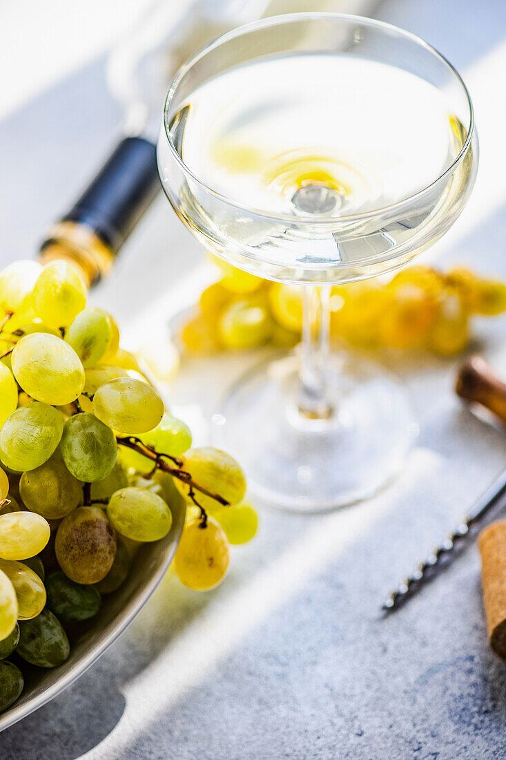 Georgian Mtsvane wine in glass and fresh raw grape on rustic table